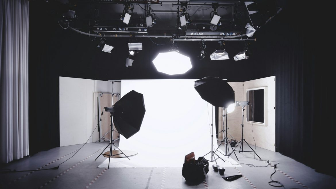 Interior of a photo shooting studio with bright lights and a professional camera.
