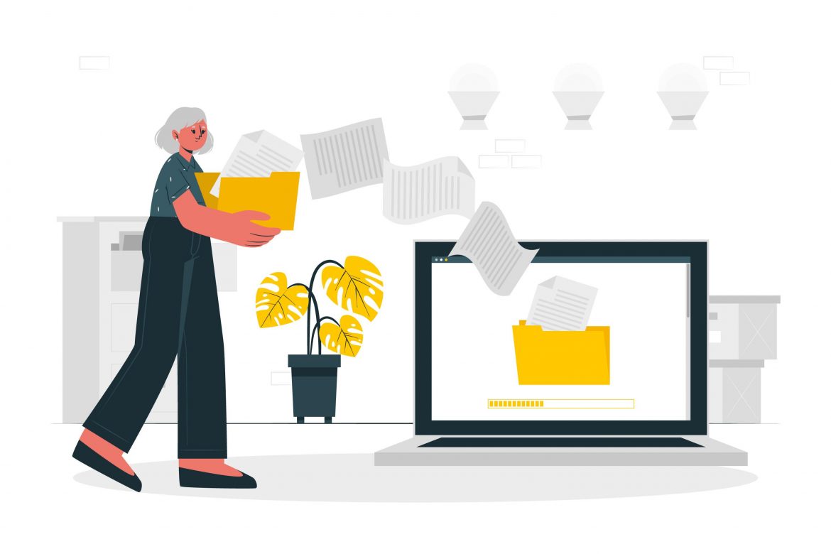 A woman transferring documents onto a laptop.